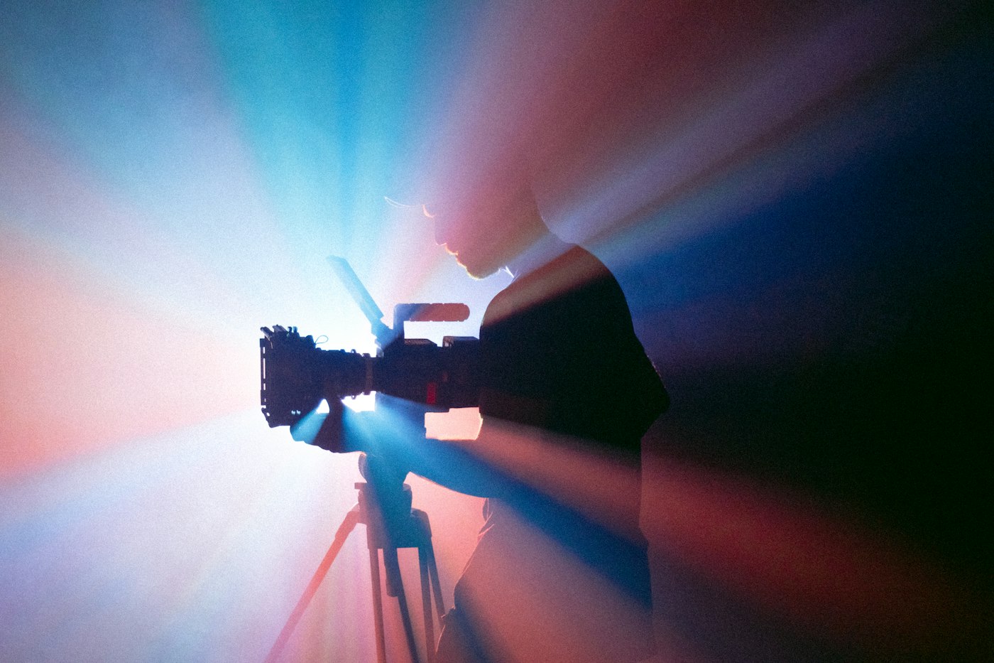 Un vidéaste filme sur trépied dans la lumière